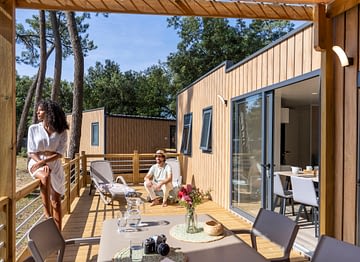 Camping Le Logis - Accommodaties - Lachend stel op het terras van een premium stacaravan
