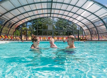 Camping Parc du Val de Loire - Couple avec son bébé qui se baigne dans la piscine couverte