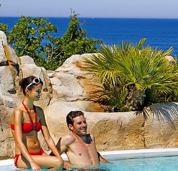 Campingplatz Le Bois de Valmarie - Aquapark - Paar beim Entspannen im Pool mit dem Mittelmeer am Horizont