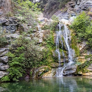 Domaine de Bagheera, Erlebnis, Ucelluliner Wasserfall in Korsika, umgeben von einer üppigen Vegetation und Felsen