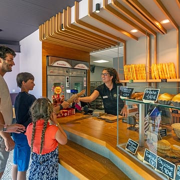 Camping Les Mouettes - Diensten - Gezin koopt een stokbrood bij de bakker