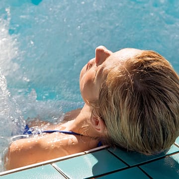 Les Mouettes campsite - Wellness - Woman relaxing in the Jacuzzis in the balneotherapy area