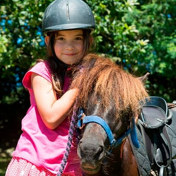 Camping Les Mouettes - Activités et animations - Enfant à côté d\'un poney