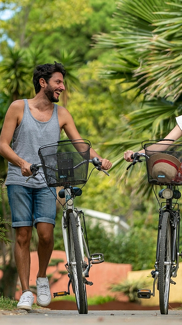 Camping La Sirène - Pareja en bicicleta en un sendero peatonal