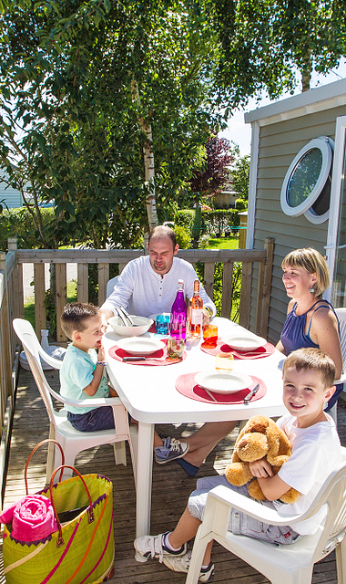 Camping Le Ridin Le Crotoy, famille déjeunant sur la terrasse d\'un cottage