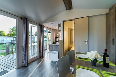 Int&eacute;rieur lumineux du Mobil-home Simply Riviera avec acc&egrave;s direct &agrave; la terrasse au Domaine de Mesqueau, Bretagne.