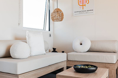 salon du nouveau Lodge &Ocirc; Grand Large de 40 m&sup2; avec terrasse couverte, h&eacute;bergement premium 3 chambres au camping Mesqueau