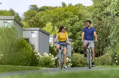 Campingplatz Les Mouettes - Mietunterkünfte - Paar auf dem Fahrrad in den Alleen
