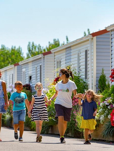 Camping Amfora - Tout pour les enfants - Les animateurs et les enfants dans les allées arborées du camping