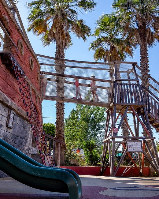 Camping Californie Plage - Galerie photo - Aire de jeux avec toboggans et pont suspendu dans l\'aire de jeux