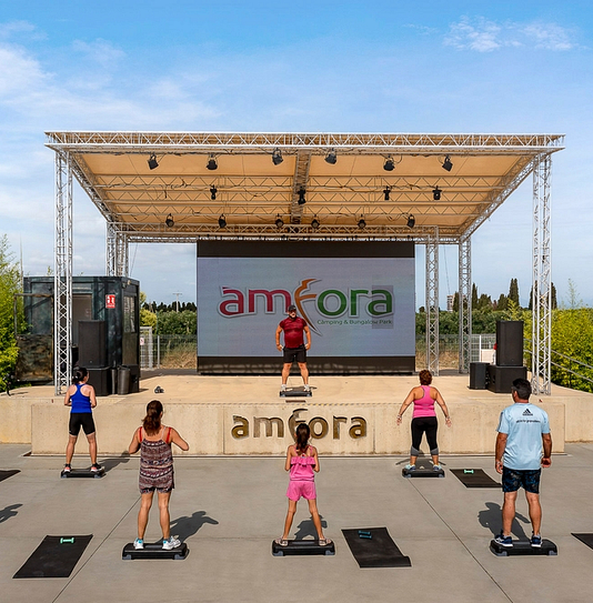 Camping Amfora - Activités et animations - Coach de fitness donnant un cours sur la scène du camping