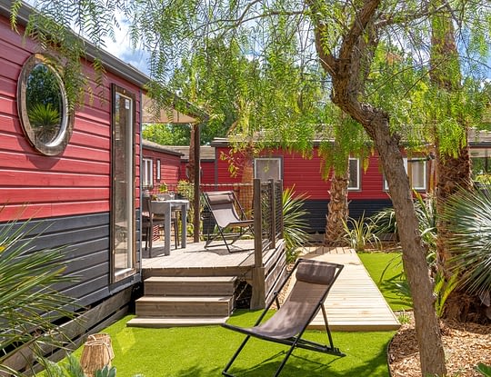 Campingplatz Californie Plage -- Mietunterkünfte - Mobilheim Cap\'tain Crochet 4 Personen - Blick von der überdachten Terrasse und vom Außenbereich