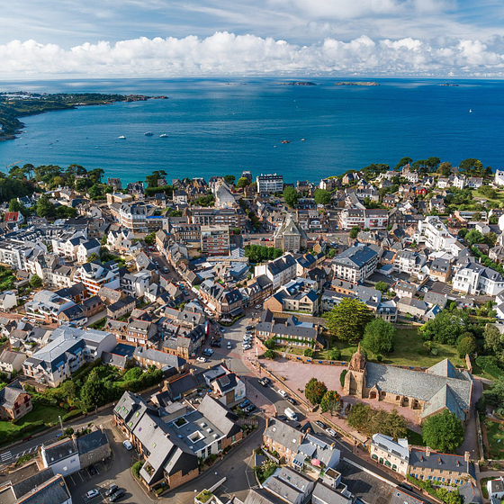 Vue a&eacute;rienne de Perros-Guirec en Bretagne, montrant la diversit&eacute; urbaine et les eaux bleues de la c&ocirc;te avec des &icirc;les &agrave; l\'horizon