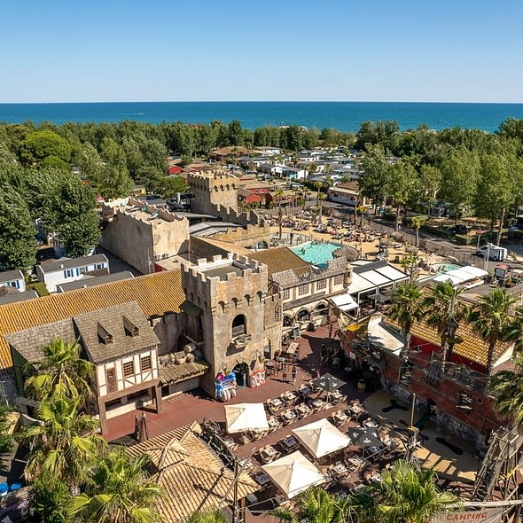 Camping Californie Plage - Galerie photo -Vue aérienne sur la place des pirates et une vue sur les locations et la mer