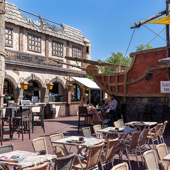 Camping Californie Plage - Galerie photo - Place des pirates avec la terrasse du restaurant \"le Black Pearl\"