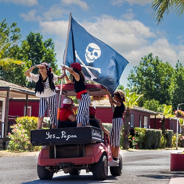 Camping Californie Plage - Le club enfants - Journée spéciale pirates avec des enfants déguisés portant un drapeau pirate