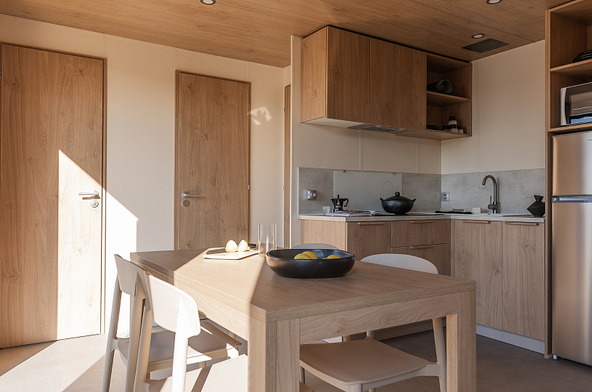 Cuisine moderne du Lodge &Ocirc; COZY 804 avec lave-vaisselle, r&eacute;frig&eacute;rateur-cong&eacute;lateur, micro-ondes et plaques de cuisson.