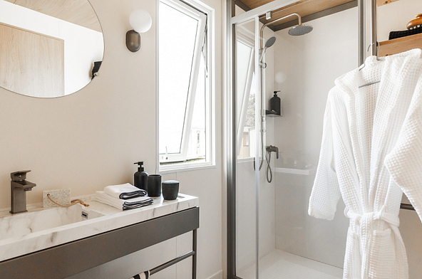 Salle de bains moderne du Lodge &Ocirc; COZY avec douche XL, meuble vasque et fen&ecirc;tre.