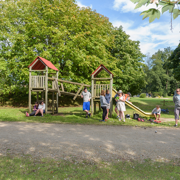 Familles et enfants profitant des jeux ext&eacute;rieurs et d\'une partie de p&eacute;tanque au camping Domaine de Mesqueau &agrave; Plougasnou.