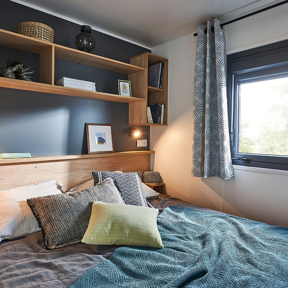 Chambre lumineuse avec lit queen size (160x200) et espace b&eacute;b&eacute; ou dressing attenant dans un Lodge Premium au Domaine de Mesqueau, camping 4 &eacute;toiles en Bretagne.