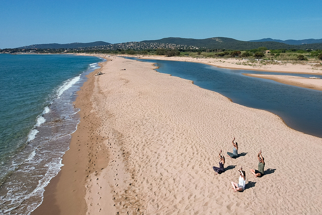 Eine Gruppe, die auf dem Strand Les Esclamandes Yoga macht - Campingplatz Fréjus Ecolodge L‘Etoile d\'Argens