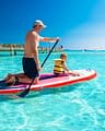 Domaine de Bagheera, Experience, A father and his young son have fun on a paddleboard on Santa Gulia beach, in Corsica